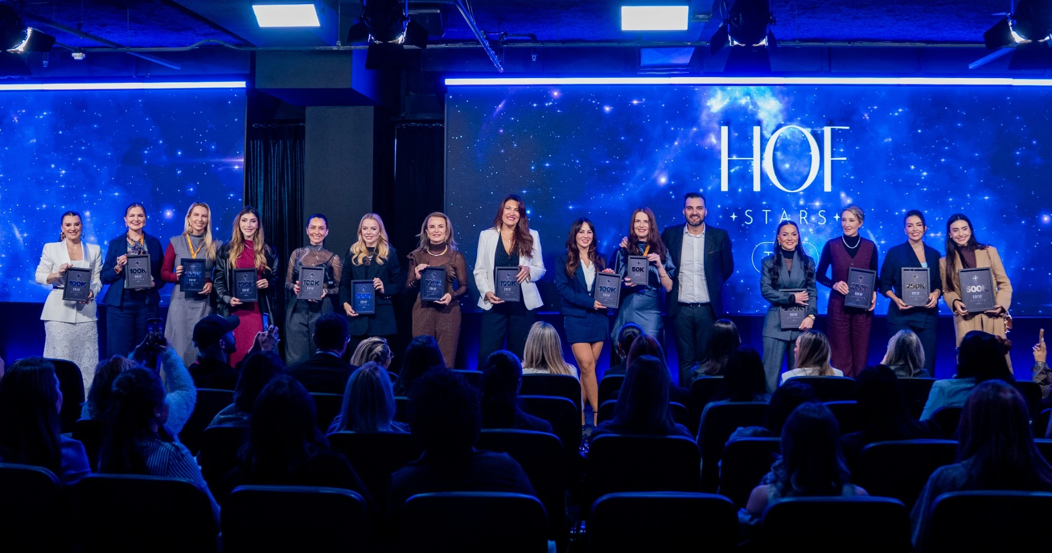 Profissionais da comunidade HOF Stars recebendo placas de reconhecimento no palco